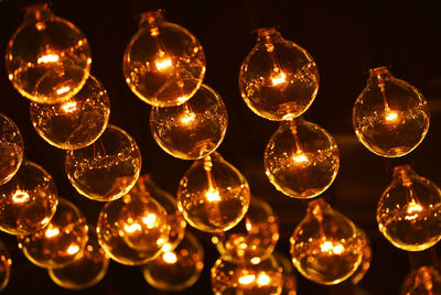 Full frame shot of illuminated light bulbs hanging in darkroom