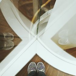 Low section of person standing on hardwood floor