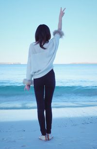 Rear view of woman standing on beach