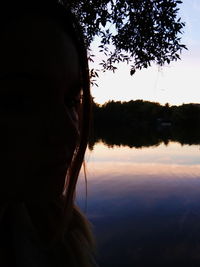 Portrait of silhouette woman by lake against sky during sunset