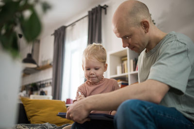 Side view of young man sitting at home