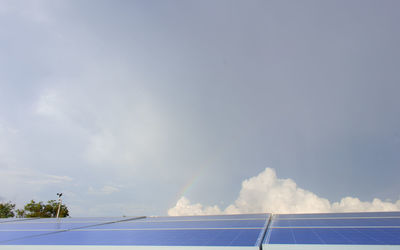 Low angle view of electricity pylon against blue sky