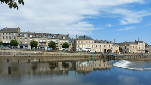 Reflection of buildings in river against sky