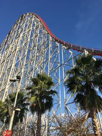 Low angle view of ferris wheel against blue sky