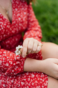 Close-up of woman holding red flowers