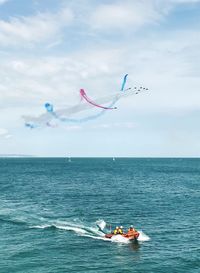 People flying over sea against sky