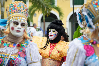 People wearing venetian carnival-style masks are seen during the carnival