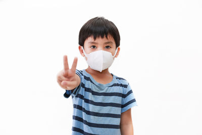 Portrait of boy standing against white background