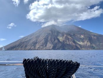 Scenic view of sea by mountains against sky