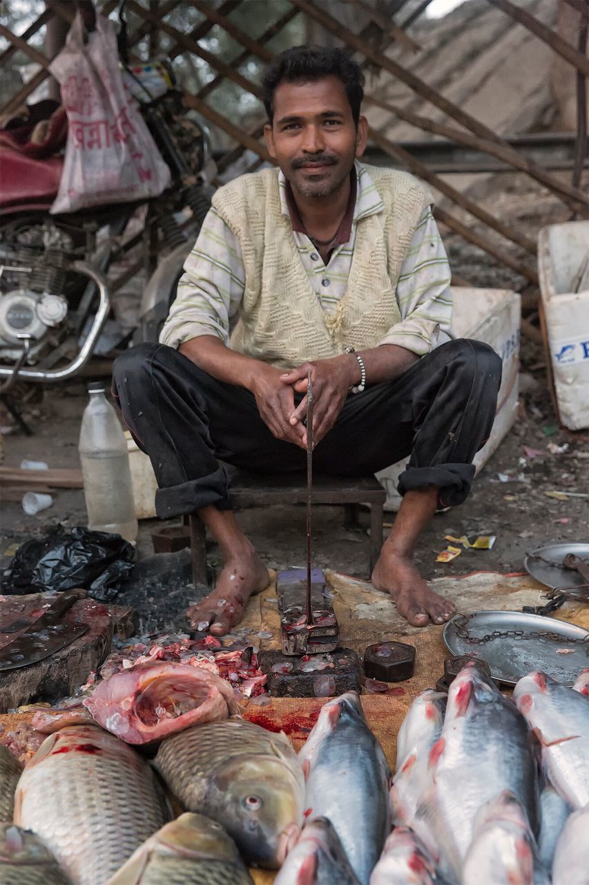 one person, fish, seafood, real people, food and drink, market, men, food, retail, freshness, occupation, one man only, fish market, looking at camera, business, portrait, only men, outdoors, day, adult, people, butcher, adults only