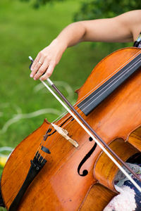 Cropped hand of woman playing violin at park