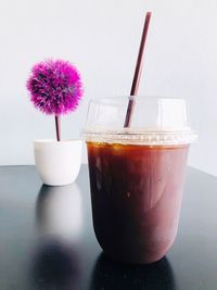 Close-up of glass of pink flower on table