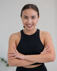 Portrait of young woman standing against white background