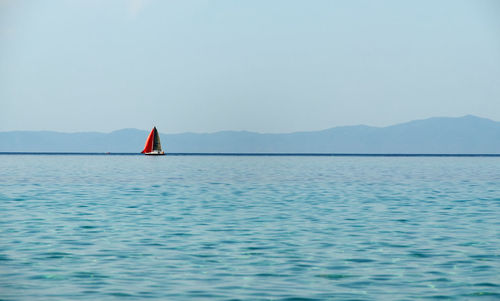 Red sailing boat and aegean sea in greece