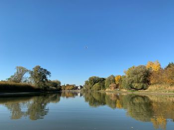 Scenic view of lake against clear blue sky