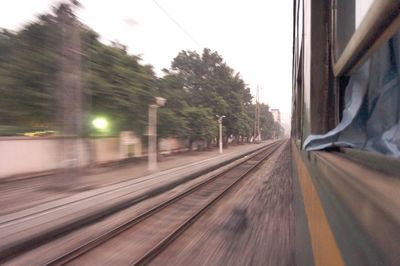 View of railroad tracks through train window
