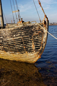 Fishing boat moored on sea against sky