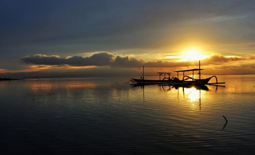 Silhouette boat in sea against sky during sunset