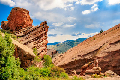 Rock formations on landscape against cloudy sky