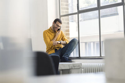 Young businessman in office talking on the phone