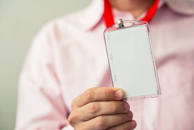 Man holding identification white blank plastic id card.