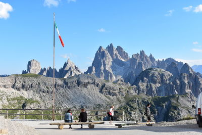 People on rocks against mountain range