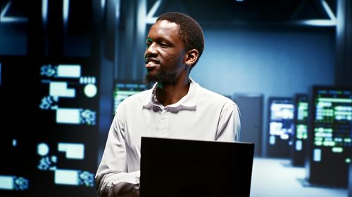 Side view of young man using laptop in office