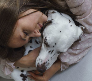 Midsection of woman with dog on bed