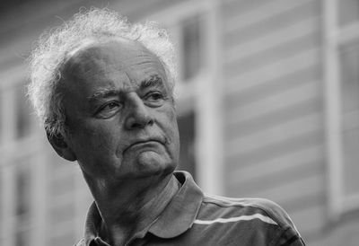 Close-up of senior man standing against wall