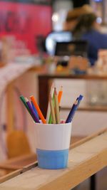 Multi colored pencils in container on table
