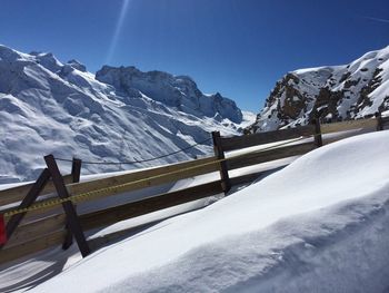 Scenic view of snowcapped mountains against blue sky