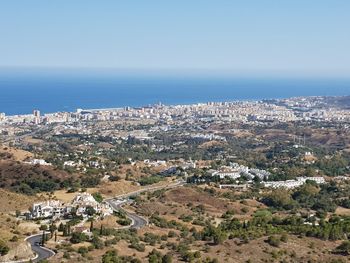 High angle view of townscape by sea against sky