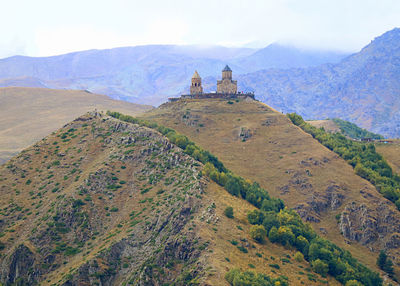 Incredible view of the gergeti trinity church on the hilltop, stepantsminda town, georgia