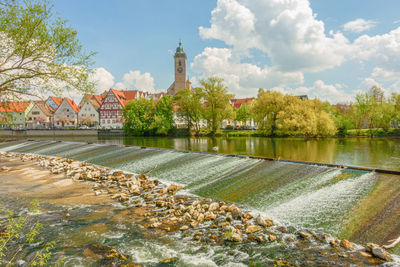 Scenic view of river by building against sky