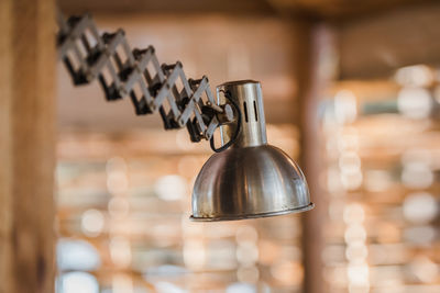 Close-up of electric lamp on table against wall