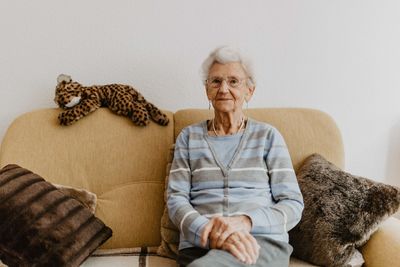 Portrait of woman sitting on sofa at home