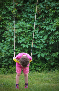 Boy leaning on swing in playground