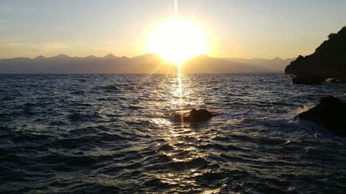 Scenic view of sea and mountains during sunset