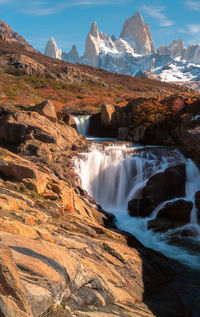 Scenic view of waterfall against sky during winter