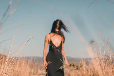 Woman standing on field against sky