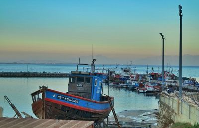 Boats in sea at sunset