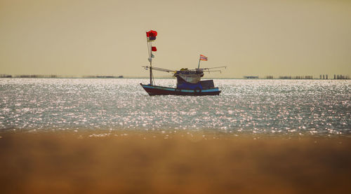 Boat sailing in sea against clear sky