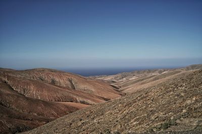 Scenic view of desert against clear blue sky