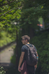 Young man looking away in forest