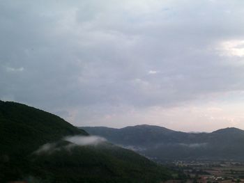 Scenic view of mountains against cloudy sky