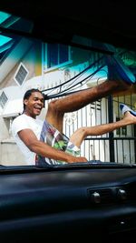 Full length of a smiling man sitting in car