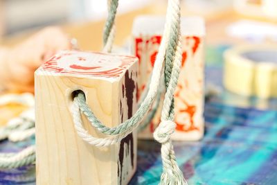 Close-up of wooden block with rope on table