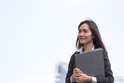 Businesswoman looking away while holding file