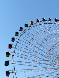 Low angle view of ferris wheel against blue sky