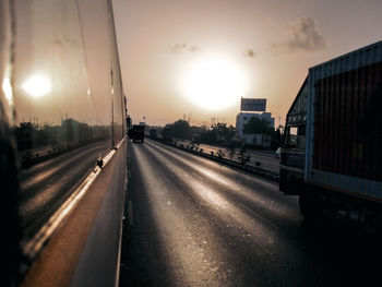 Road in city against sky during sunset